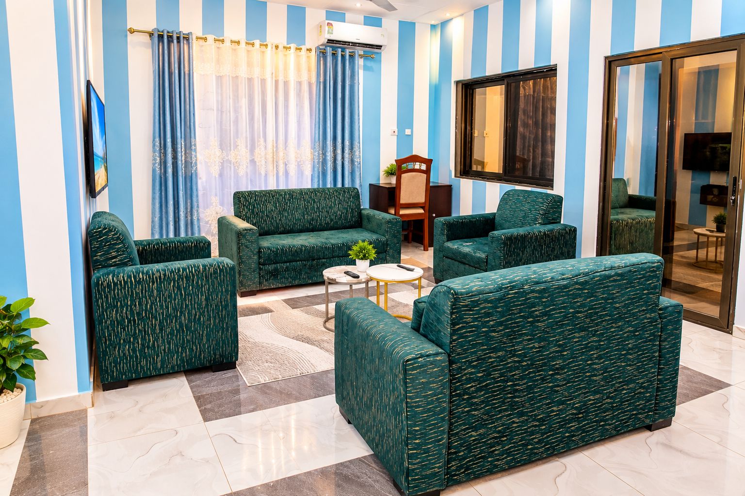 A living room with striped walls, a sofa set, a coffee table, and a television.