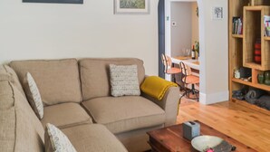 Una sala de estar con un sofá, una mesa de centro y una estantería.