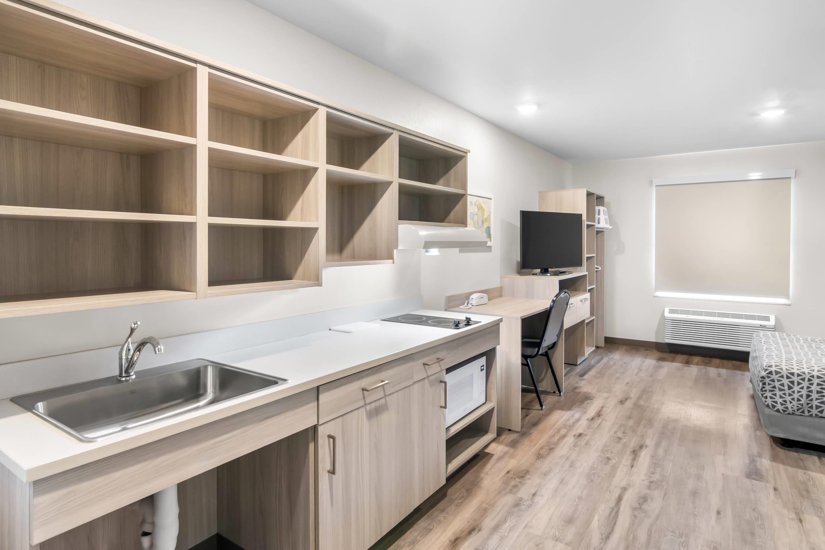 A modern kitchen with built-in cabinets, a sink, and a microwave.