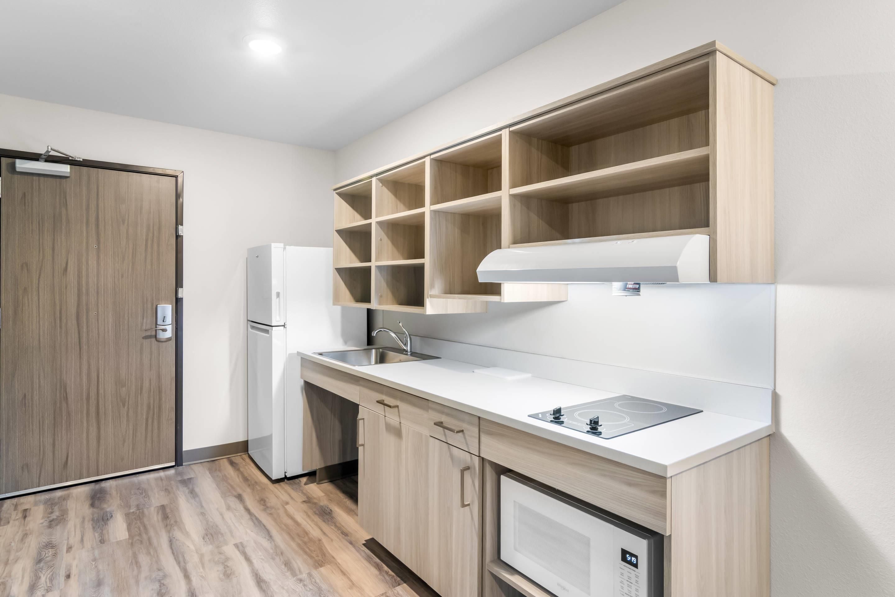 A modern kitchen with a built-in microwave, a sink, and a stove.