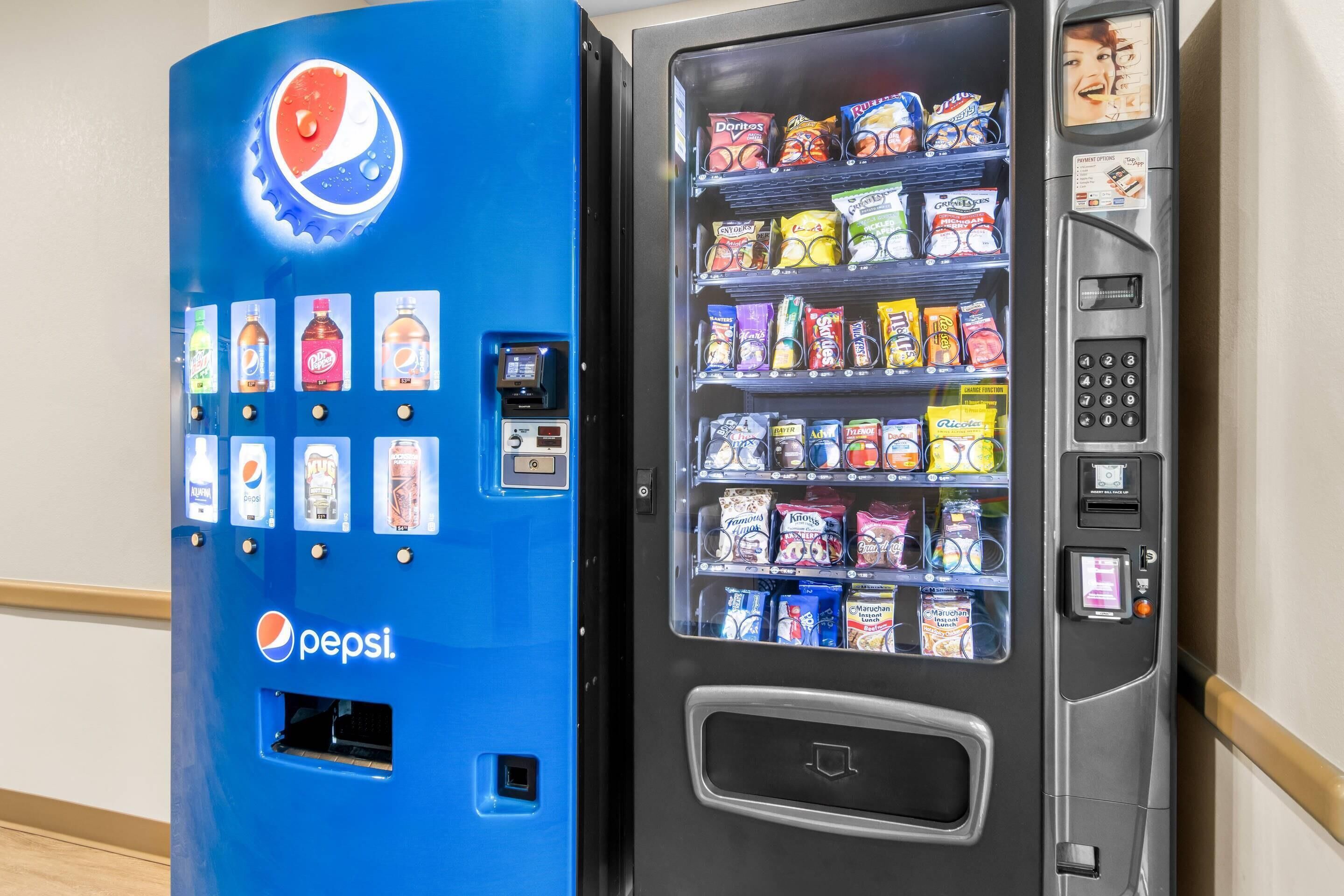 Máquina expendedora con el logotipo de Pepsi, que ofrece diversos snacks y bebidas.
