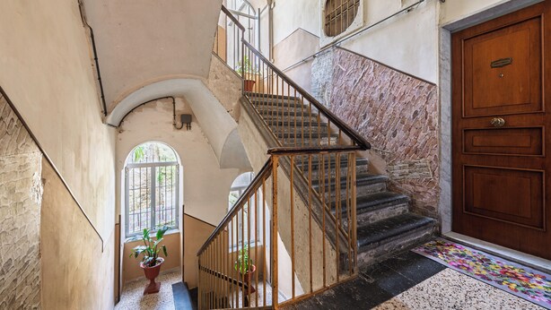 A staircase with metal railings, a wooden door, and a patterned mat at the bottom. - Casa Luce del Sole - Two Bedroom Apartment, Sleeps 5 (Naples)