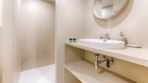 A modern bathroom with a white sink, mirror, and bathtub. - Superb Air-conditioned Duplex Bastille Le Marais (Paris)