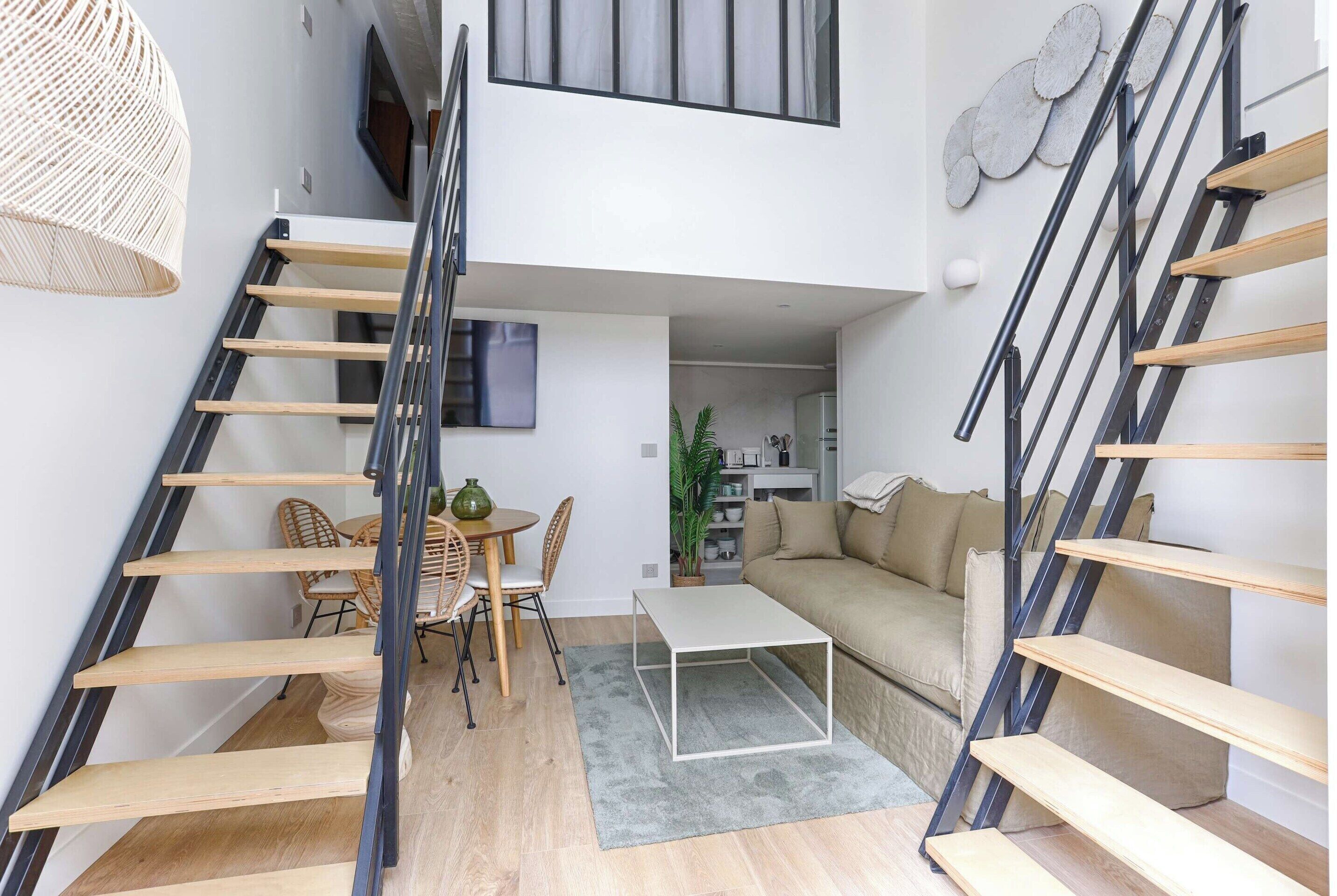 Un intérieur moderne comprenant un escalier, un coin repas et un espace de vie.