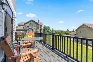 A wooden deck with a table and chairs, a railing, and a view of a house and trees. - New Egg Harbor Construction with Pool,Hot Tub,Gym (Egg Harbor)