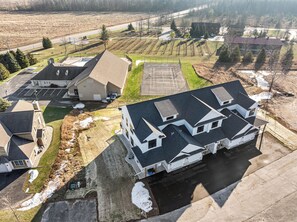 An aerial view of a residential area with houses, a parking lot, and a vineyard. - New Egg Harbor Construction with Pool,Hot Tub,Gym (Egg Harbor)