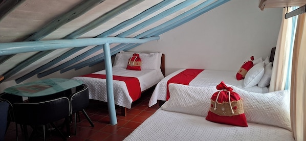 Una habitación pequeña y acogedora con dos camas, una mesa y una silla.