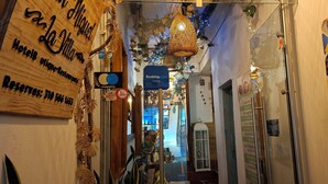 A narrow hallway with a wooden sign for 'Hotel La Villa' and a 'Booking.com' sign. - San Miguel Villa Hotel's VDL (Villa de Leyva)