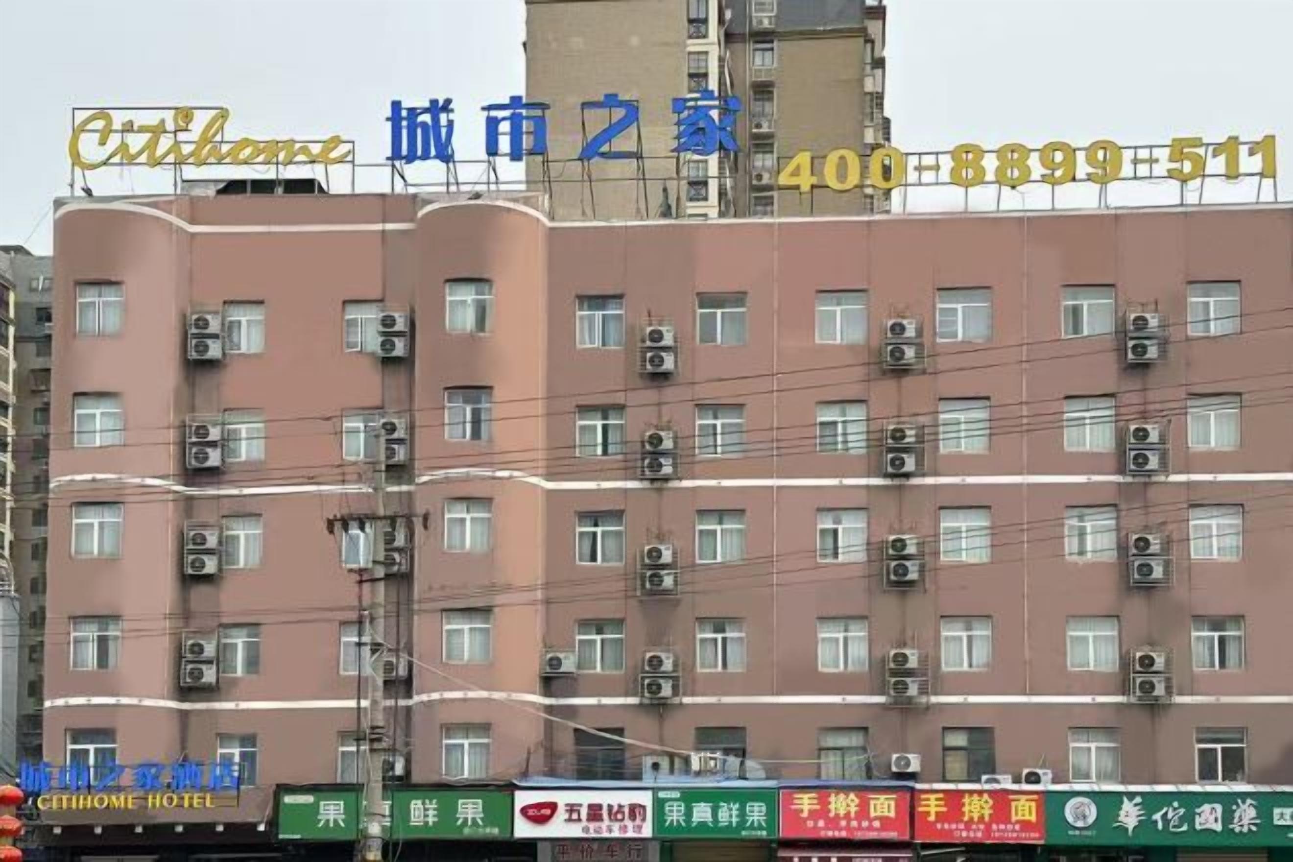 Un edificio de varios pisos con numerosas ventanas y unidades de aire acondicionado.