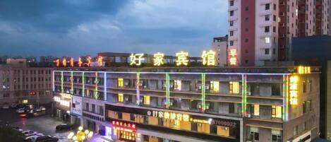 A multi-story hotel with illuminated signage and a parking lot.
