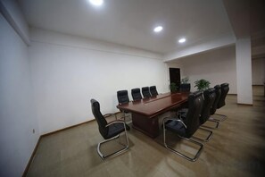 A conference room with a long table, six chairs, and a potted plant. - Luohe Haojia Express Hotel (Jiaohe)