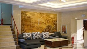 Een moderne woonkamer met een bank, salontafel en een decoratieve wand.