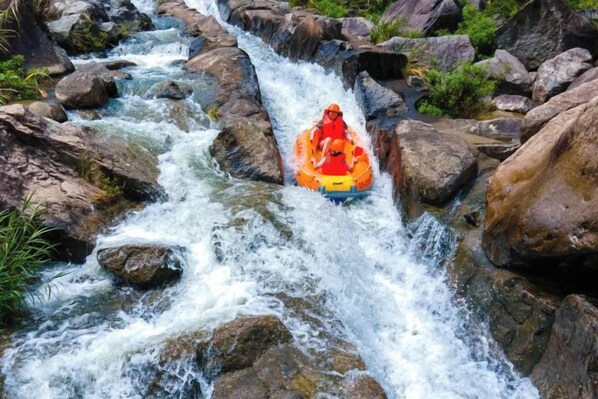A person in a raft navigating a narrow, rocky water channel.