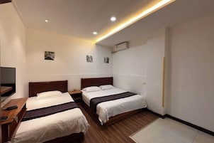Una habitación de hotel con dos camas individuales, un escritorio y una televisión.