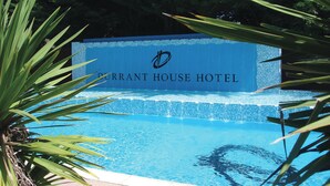Un espace piscine avec un panneau indiquant « Durrant House Hotel ».