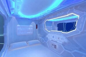 A futuristic room with a control panel, a window, and a metallic wall. - Harbour Hella Inn (Hong Kong)