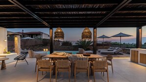 An outdoor patio with a pool, dining area, and lounge chairs.
