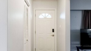 A hallway with a white door, a black rug, and a ceiling light fixture. - Beautiful Home In A Prime Location (Winnipeg)