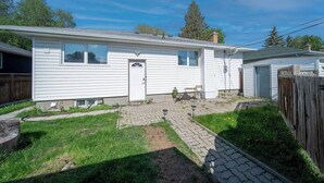 A single-story mobile home with a front door, a small patio area, and a fenced backyard. - Beautiful Home In A Prime Location (Winnipeg)