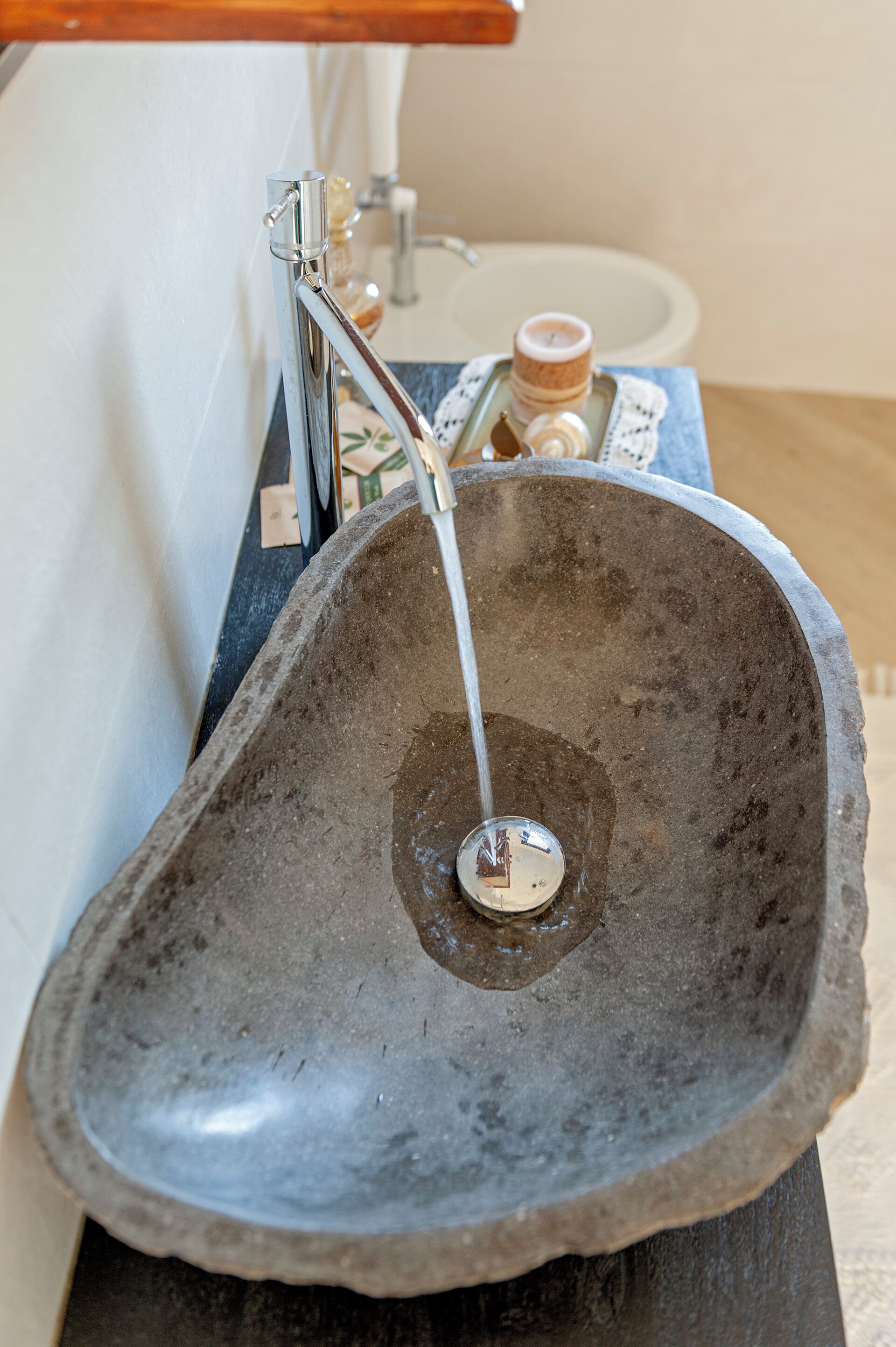 Ein Waschbecken aus Stein mit Wasserhahn und Seifenspender.