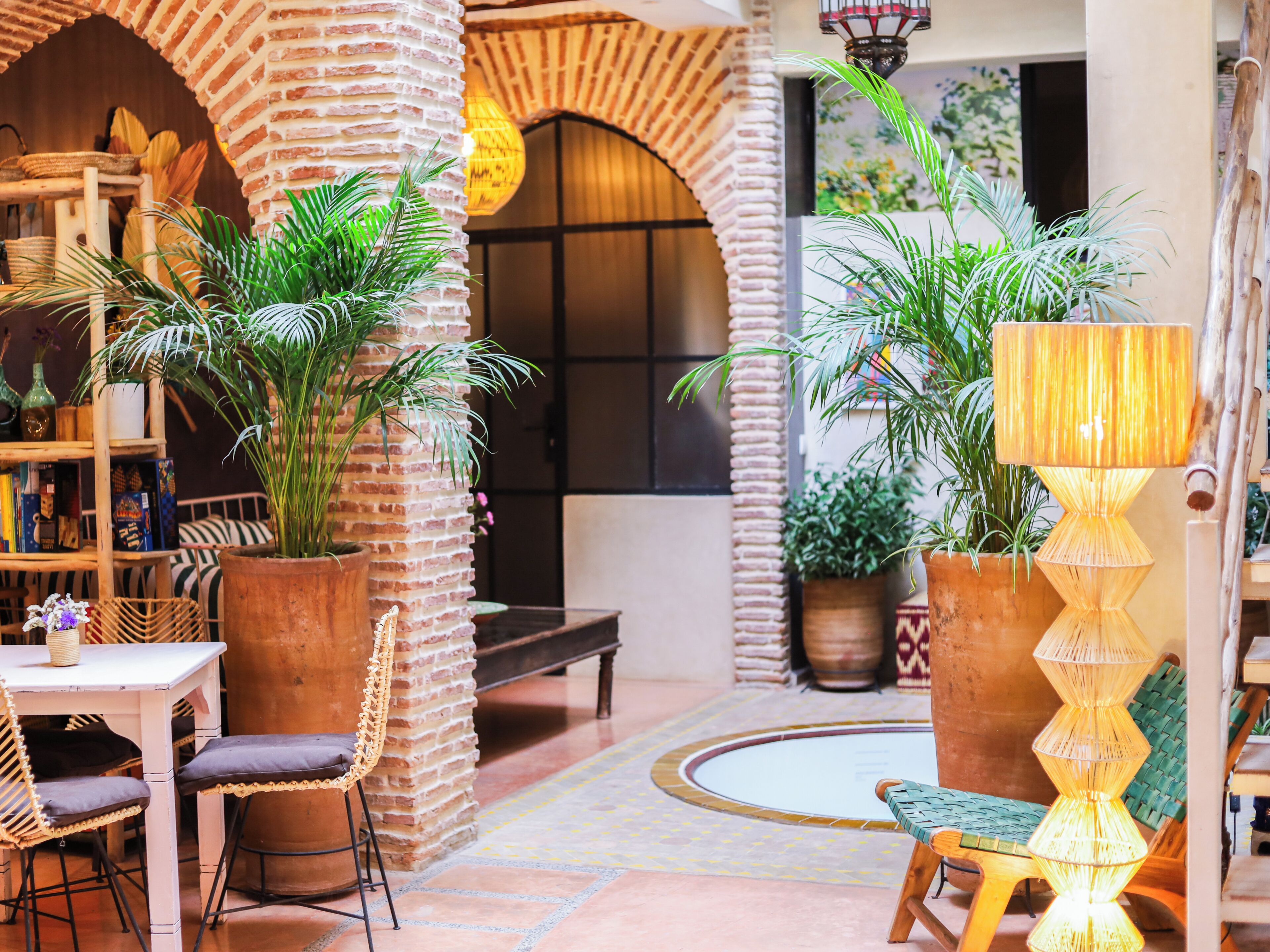 Un patio interior acogedor con paredes de ladrillo, muebles de madera y plantas en macetas.