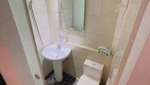 A small bathroom with a sink, toilet, and shower. - Ching Shang Tien Hua (New Taipei City)