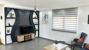 A modern living room with a fireplace, a dining table, and seating area.