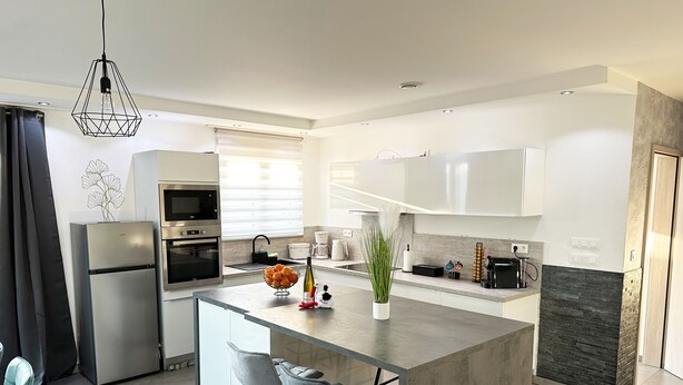 A modern kitchen with a central island, built-in appliances, and a minimalist design.
