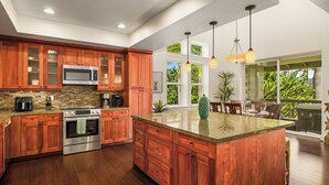 Una cocina amplia con armarios de madera, electrodomésticos de acero inoxidable y una isla grande.