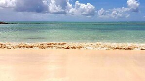 Una playa con agua turquesa cristalina y una orilla arenosa.