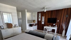 Un dormitorio moderno con una cama grande, un escritorio y una zona de estar.