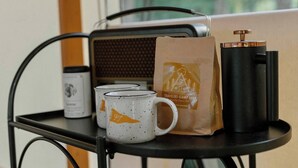 A metal cart with a coffee maker, a bag, and a mug on a table. - Field Trip Unit 5 XL Canvas Cabin Family & Dog-Friendly (Travelers Rest)