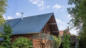A wooden house with a sloped roof and a balcony. - Villa Nature (Pougny)