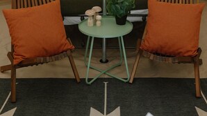A tent with a bed, two chairs, a small table, and a plant. - Field Trip Unit 8 Small Bell Tent (Travelers Rest)