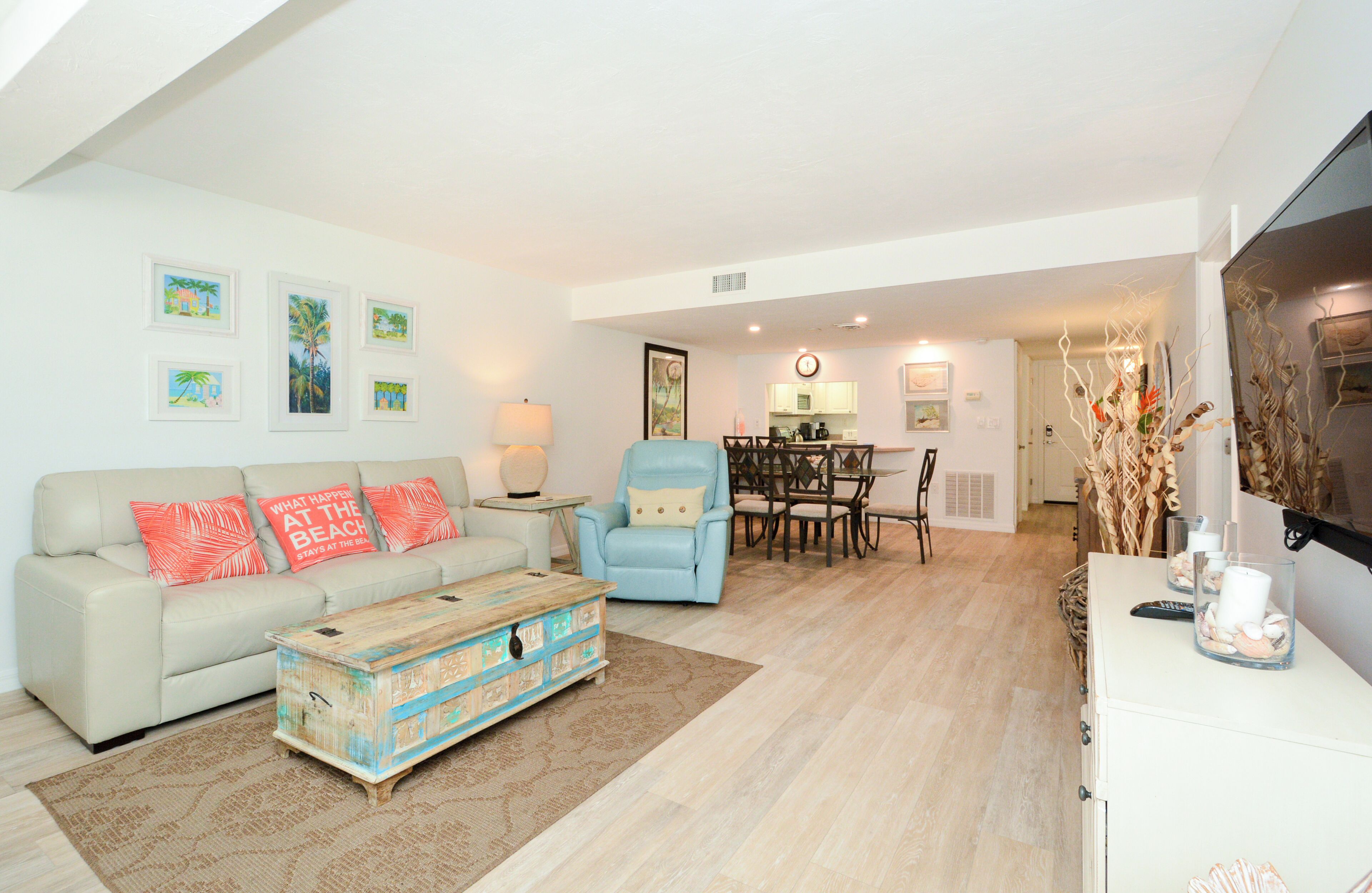 A living room with a sofa, armchairs, a coffee table, and a dining area with a table and chairs.