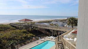 A beachside resort with a pool, lounge chairs, and a wooden deck overlooking the ocean. - Stunning Oceanfront Retreat w/ Private Pool, Elevator, Handicap Accessibility (Ocean Isle Beach)