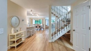 Un pasillo amplio con una escalera, un comedor y una cocina.