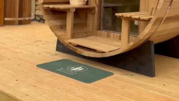 A wooden barrel-shaped cabin with a small table and chair inside. - Field Trip Unit 16 GeoDome (Travelers Rest)