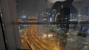 A nighttime cityscape with modern buildings and a busy highway. - Burj Khalifa DownTown Hostell (Dubai)