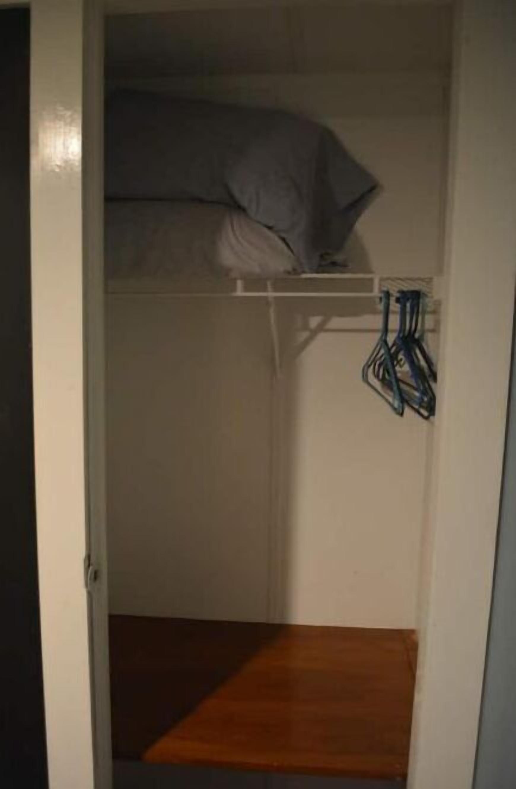 Een kleine, afgesloten ruimte met een stapelbed en een houten platform onder.