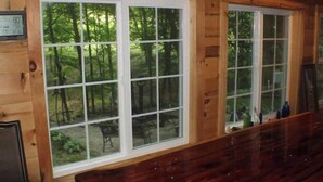 A cabin with large windows offering views of a forested area.