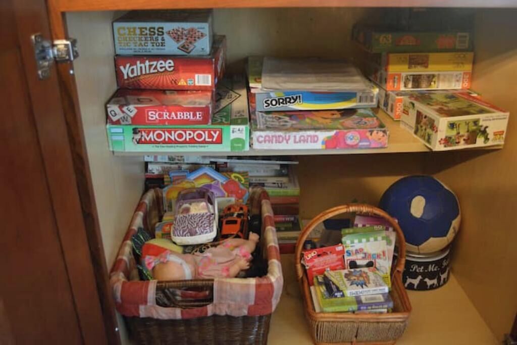 Una repisa con juegos de mesa como ajedrez, Scrabble y Monopoly.