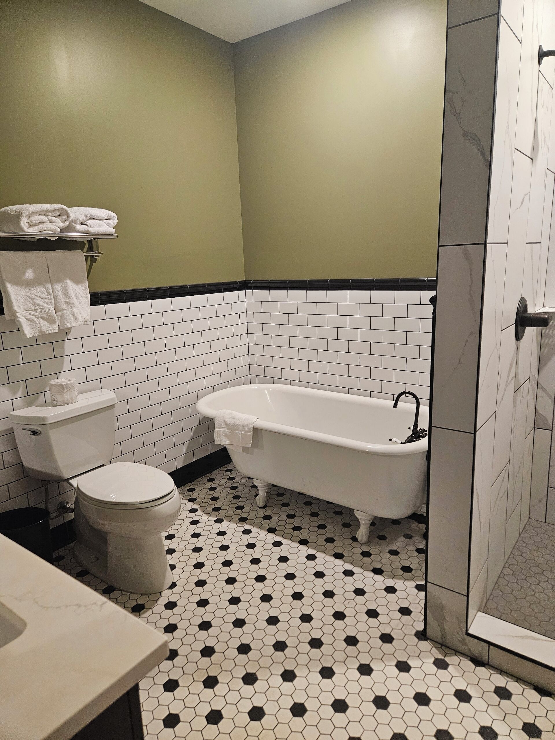 A bathroom with a toilet, bathtub, and shower.