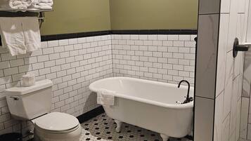 A bathroom with a toilet, bathtub, and shower.