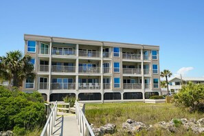 Un hôtel à plusieurs étages doté de balcons, d’une terrasse en bois et offrant une vue dégagée sur le paysage environnant.