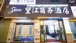 A hotel entrance with a sign that reads "NANYOU HOTEL CHAN" and "NANYOU HOTEL CHAN" in English. There are promotional posters on the door and a red carpet leading inside. - Nanyou Hotel Lijiang Wangjiang Business Hotel (Lijiang)
