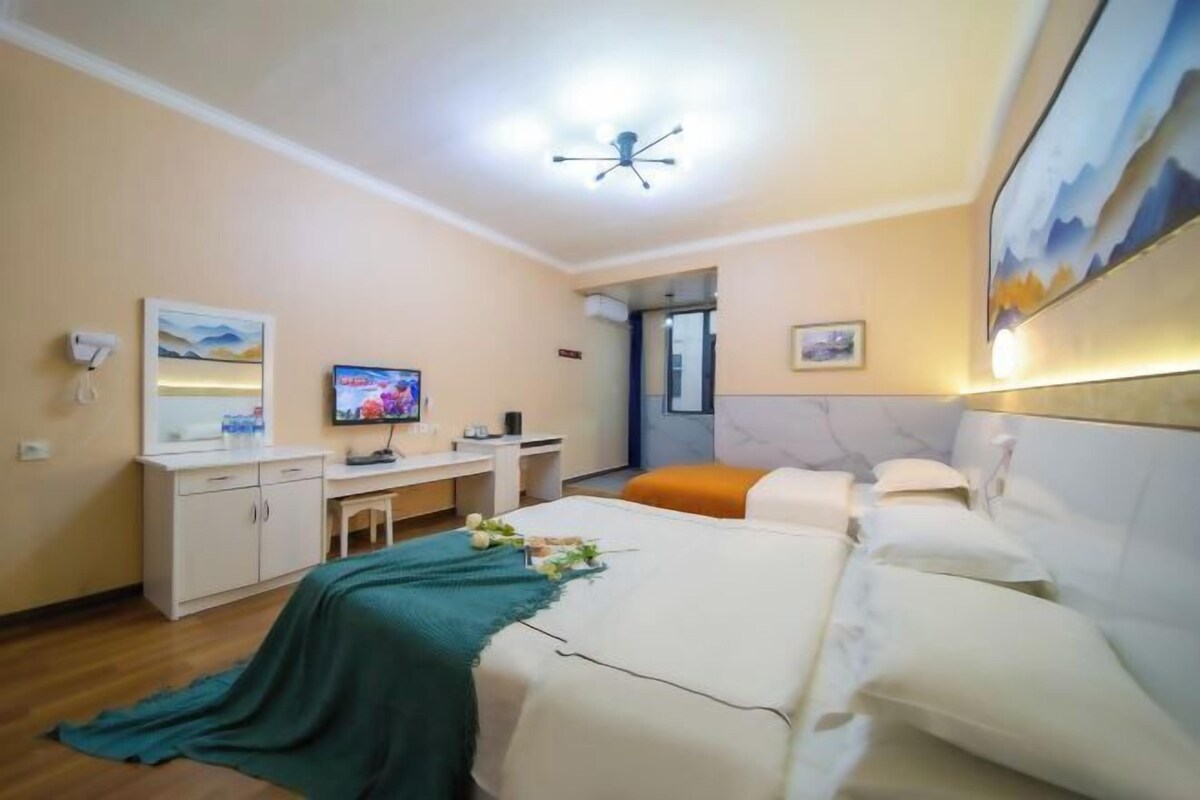 Hotellihuone, jossa on sänky, työpöytä, televisio ja kylpyhuoneen ovi.