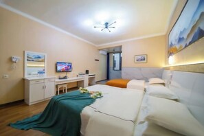 Ein Hotelzimmer mit Bett, Schreibtisch, Fernseher und Badezimmertür.