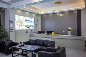 Un espace d’accueil moderne comprenant un canapé, une table basse et un bureau.