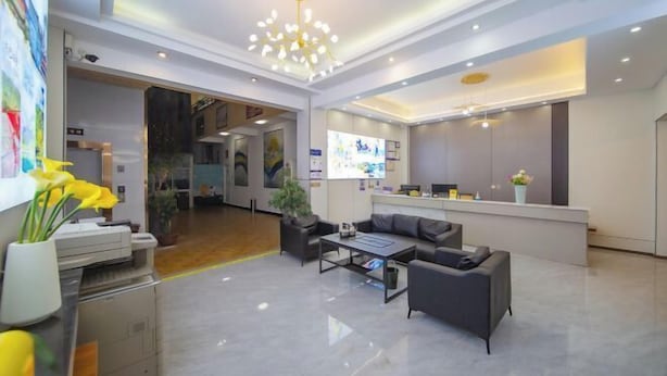 A modern hotel lobby with a reception desk, seating area, and a large chandelier. - Nanyou Hotel Lijiang Wangjiang Business Hotel (Lijiang)